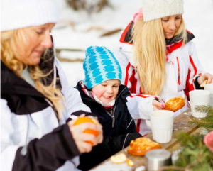 Barn och vuxna äter mellanmål i skidbacken i Väsjön Sollentuna